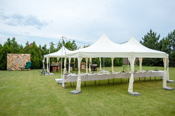 Large folding white tents in a wedding party. Place for wedding banquet outdoors. - 706328691