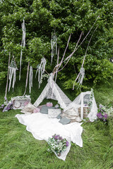 A white teepee tent in boho style in the forest