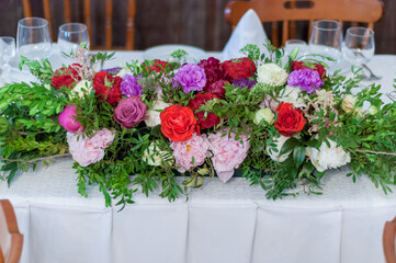Wedding table decorated with colorful flower arrangement. - 706329257
