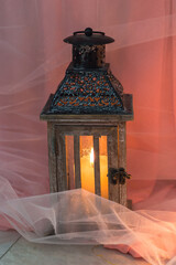Old lantern with a burning candle. Vertical photo orientation.