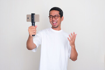 A man showing happy expression when making video content using his mobile phone