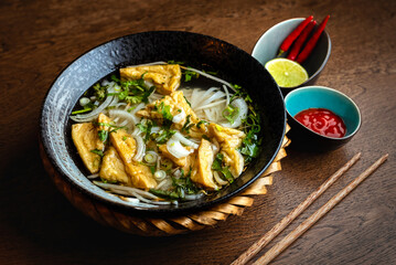 Asian vegetarian noodle soup in a ceramic plate
