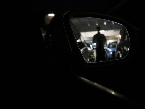 Side View Mirror Reflecting Silhouette aboard Ferry
