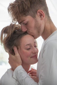 Man Kissing Woman on Forehead

