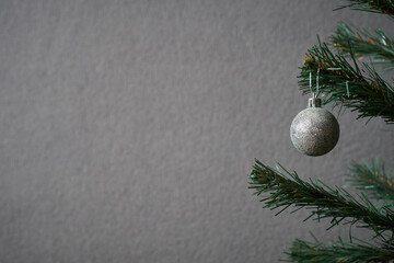 Photo of a Christmas tree decorated with a gray New Year's toy for making postcards