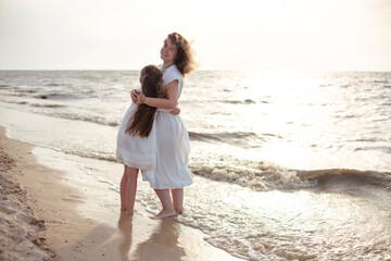 Mother and daughter hugging near sea