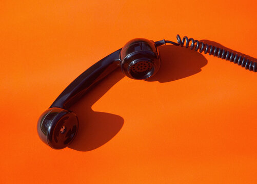 Telephone Handset on Orange Background
