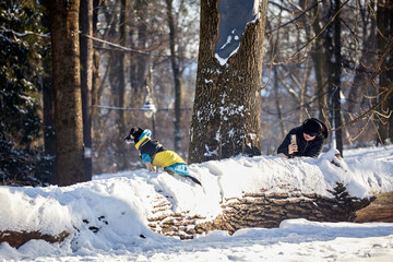 A woman captures a winter moment with her dog in a snow-covered park. A pet in a jumpsuit poses...