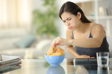 Obraz na płótnie Canvas Glutton woman eating suffering belly ache