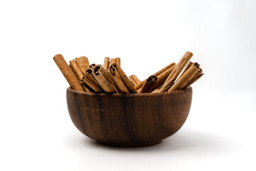 wooden bowl full of cinnamon stick with detail texture, isolated on white background