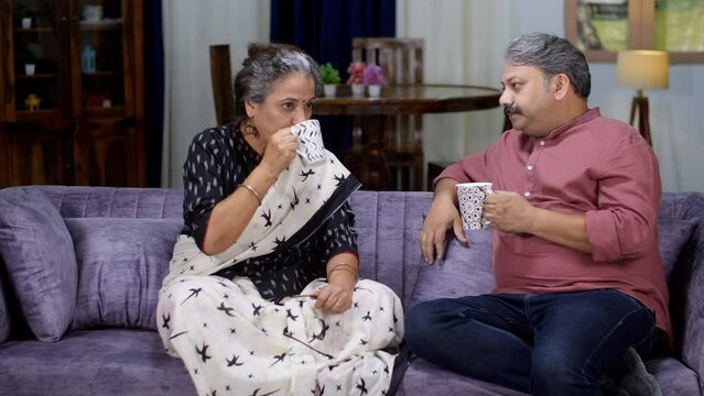 An old Indian couple in conversation over a cup of tea / coffee - retired life  old age  self-dependent  away from kids. An urban Indian husband spending quality time with his wife - elderly couple...