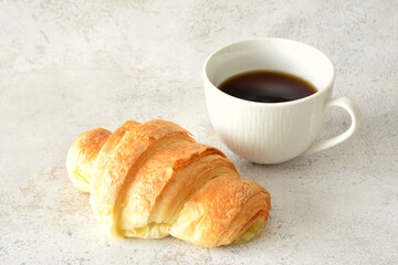 croissant with cup of hot coffee isolated close up
