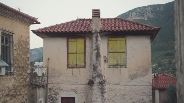 Static view of boarded up windows in Mediterranean town old building, Leonidio Greece