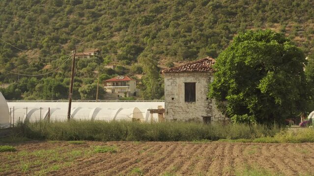 Mediterranean town farmland field with steep dry shrubs on hillside, static
