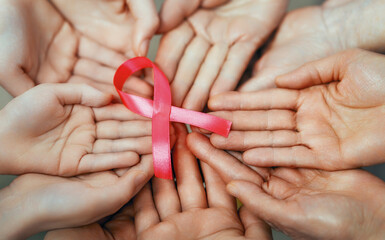 Hands of women with pink ribbon