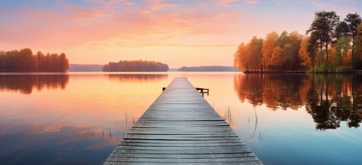 Serene autumn lake view with wooden pier during sunset. Tranquil nature scenery.