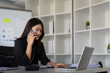 Happy confident businesswoman talking on the phone. Smiling female business person talking work using talking on the phone at office sitting at desk