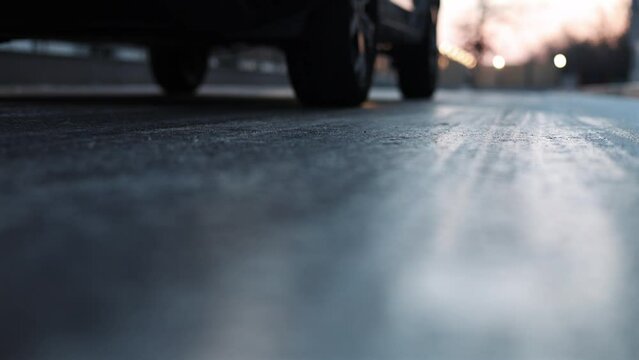 Glazed frost on the asphalt. icy road danger for driving. Close up 4k video of a road covered with ice after a snowfall and freezing rain. Selective focus.