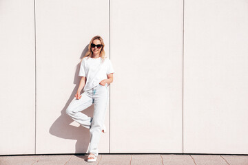 Portrait of beautiful smiling model in sunglasses. Female dressed in summer hipster white T-shirt...