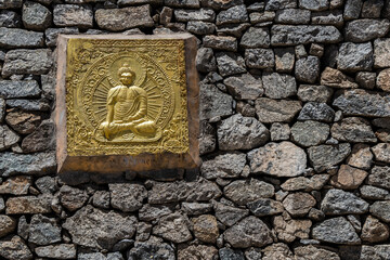 A beautiful golden Buddha figure on the wall with copy sapace.