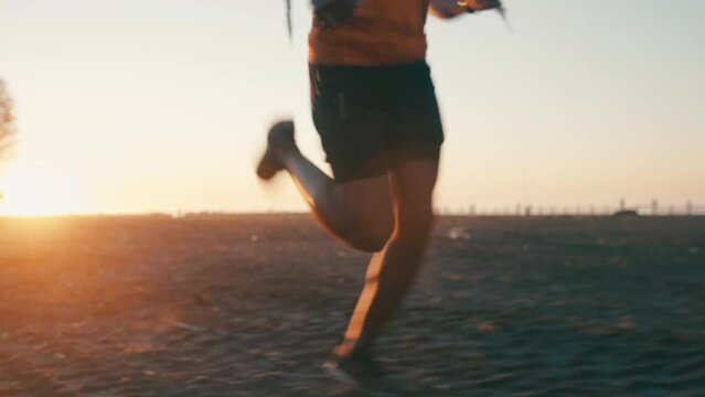 Legs, sunrise and person run in park, health and wellness with speed, endurance and energy. Exercise, fitness and runner outdoor in nature for race, train for marathon with lens flare and sport