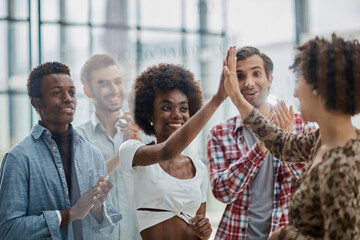 Successful business people giving each other a high five in a meeting
