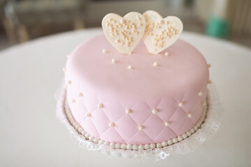 Obraz na płótnie Canvas Indulge in the heavenly delight of a pink cake adorned with two lovingly-crafted hearts, symbolizing the essence of romance in a single breathtaking confection.