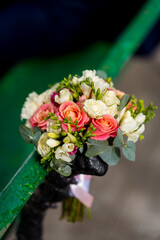An enchanting composition where a vibrant bouquet delicately perches on a lush green rail,...