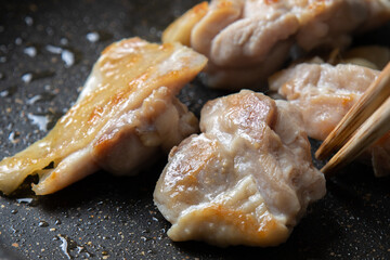 鶏肉(鶏モモ肉)をフライパンで焼く調理シーンのアップ。
