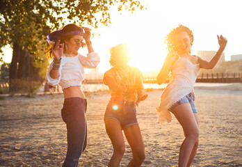 Happy slim tan women on the beach in sunset. Travel and happiness concept
