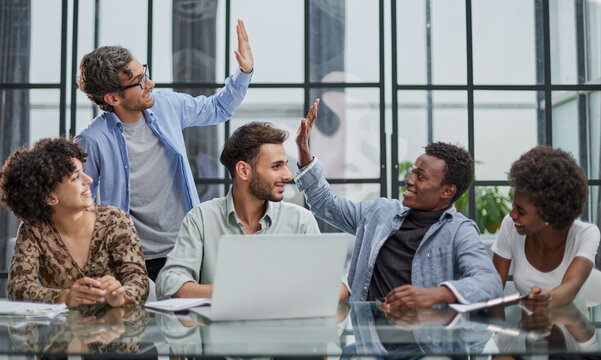 Successful Business People Giving Each Other A High Five In A Meeting