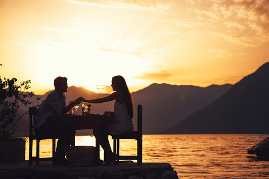Couple is having a private event dinner on a tropical beach during sunset time
