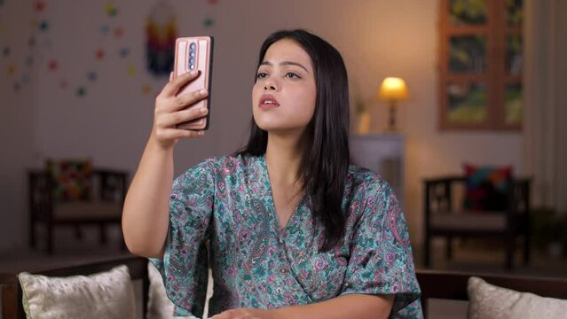 Shot of beautiful Indian girl struggling with network problem at home - network issues  internet problem . A frustrated woman checks her cellphone - no signal  dissatisfied millennial  electronic d...