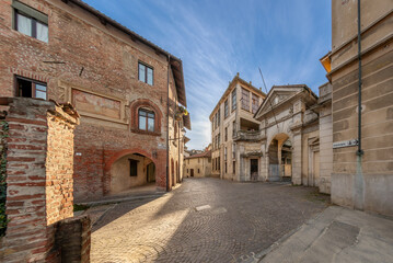 Carignano, Italy -  view of via Monte di Pieta with old medieval house with fresco and neo-baroque...
