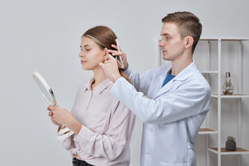 The doctor surgeon is preparing for the operation Otoplasty, Ear plastic surgery, correction of protruding ears