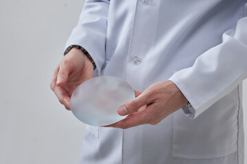 silicone breast implant in the hand of a plastic surgeon doctor, mastopexy concept, BREAST LIFT