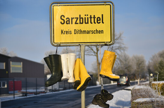 Ortsschild mit Gummistiefel, Protest der Bauern 
