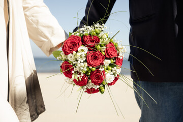 Romantisches Brautpaar am Strand mit Hochzeitsstrauß