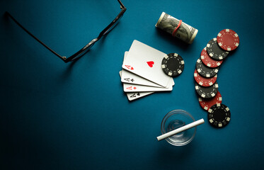 A popular poker game with a combination of four of a kind or quads. Chips and aces playing cards on a blue table in a poker club