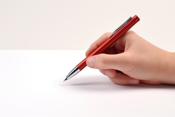 Hand holding pen and writing on white paper