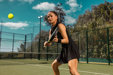 Padel tennis player with racket in action on the court. Woman athlete with paddle racket on court...