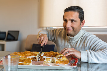 A sorie man while he cuts a roscon de reyes