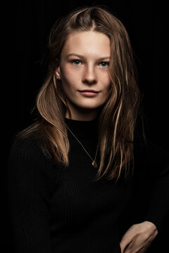 Portrait of elegant beautiful European young woman in front of a black background. Studio shot