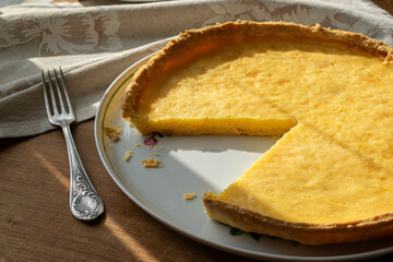 White dish with a delicious lemon pie on a wooden background
