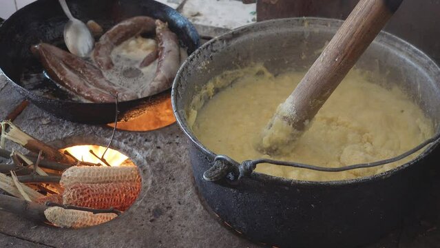 Old rustic traditional preparation of sausages and polenta on fire