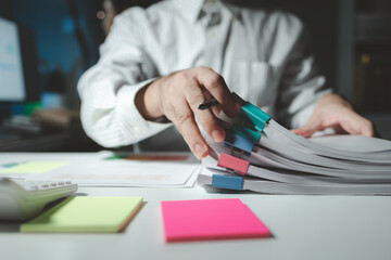 Auditor is working on accounting in the office, Businessman calculating the financial liquidity of the company, He was jotting down numbers from the company's financial documents.