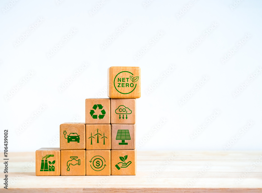 Aufkleber net zero icon and green renewable energy symbol on wooden cube block stack as graph steps isolated o