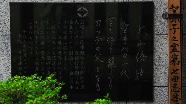 The name of Masutatsu Oyama, the founder of Kyokushinkai Karate, is written in Japanese characters. The plaque on the grave of Oyama Masutatsu. Ikebukuro, Tokyo, Japan