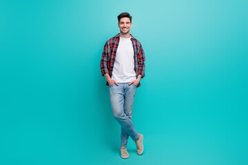 Full length photo of cheerful good mood man dressed plaid shirt smiling isolated turquoise color background