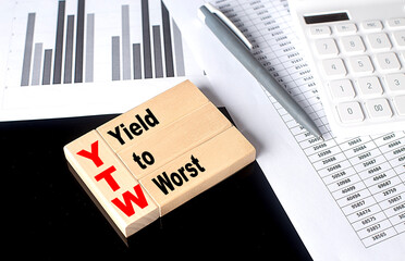 Word YTW Yield To Worst made with wood building blocks, business concept